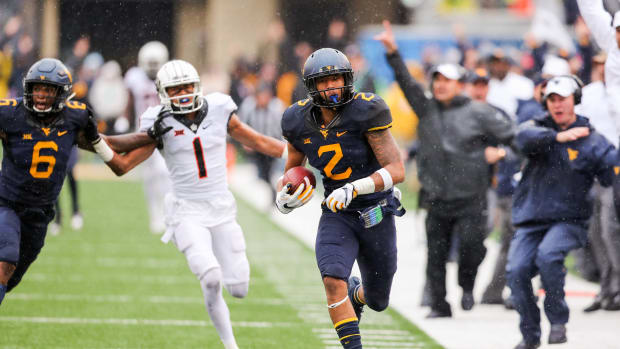 West Virginia Mountaineers safety Kenny Robinson (2) runs an interception back for a touchdown during the third quarter against the Oklahoma State Cowboys at Milan Puskar Stadium.